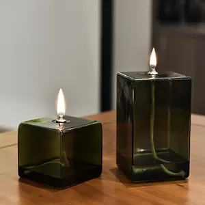 Moderne lampade a olio quadrate in vetro verde oliva su un tavolo in legno deco
