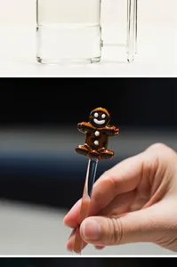 Close-up detail of a handmade glass stirring rod featuring a cute gingerbread man design