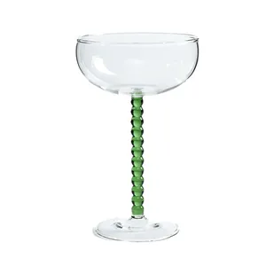 Elegante coppa in vetro con stelo a perline verdi per cocktail retrò e champagne