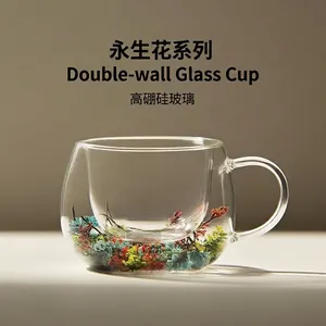 Eleganter doppelwandiger Borosilikatglasbecher mit bunten Trockenblumen