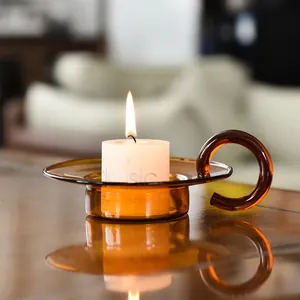 Vintage amber glass candle holder with a ring handle and a lit candle for home decor