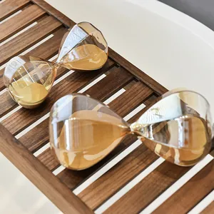 Pair of golden diamond-shaped glass hourglass timers on a wooden rack for home decor