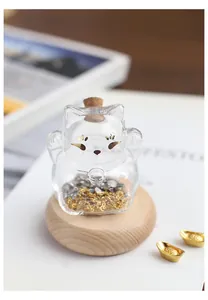 Vue détaillée d'une mini bouteille de vœux en verre en forme de chat avec décorations