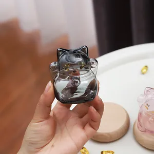 Vue détaillée d'une mini bouteille de vœux chat porte-bonheur en verre noir translucide.