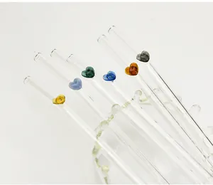 Detailansicht bunter herzförmiger Dekorationen auf hitzebeständigen Trinkhalmen aus Glas