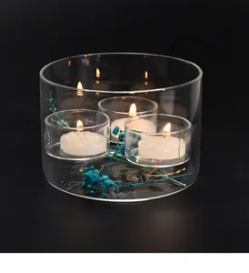 Close-up of windproof glass candle holder with three glowing tea light candles