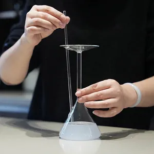 Kreativer trichterförmiger Cocktail-Glaspokal mit Glastrinkhalm für edle Barware.