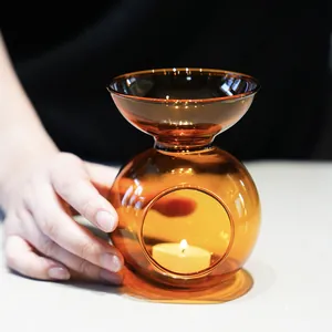 Elegant amber glass essential oil burner with a lit tea light candle for home fragrance