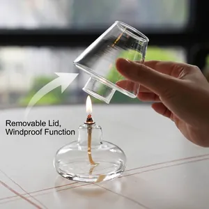 Nordic hand-blown clear glass oil lamp featuring a windproof removable cover and lit flame