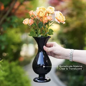 Exquisite handgefertigte schwarze Glasvase im Vintage-Stil mit gelben Rosen im Garten