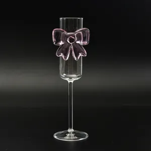 Elegant champagne flute with pink glass bow decoration on a deep black background