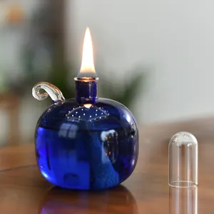 Detailansicht einer modernen blauen Glasöllampe mit einer brennenden Flamme