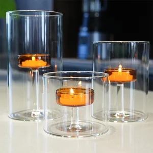 Close-up of windproof glass candle holders with warm amber tea light glow for decor