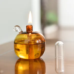 Detailansicht einer dekorativen bernsteinfarbenen Kugel-Glasöllampe mit Flamme
