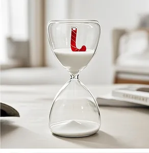 Primer plano de reloj de arena de cristal con bastón de caramelo rojo y arena blanca