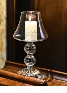 Elegant European lamp-shaped glass candle holder with a warm lit pillar candle detail