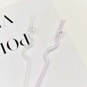 Eco-friendly wavy glass straws with elegant bow tie accents for juice and coffee