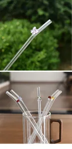 Detailed view of reusable glass straws with cute colorful butterfly and mushroom charms