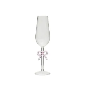 Elegante copa de champán de vidrio con un delicado lazo rosa decorativo en el tallo.