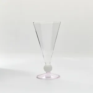 Elegante copa de champán con forma de diamante, base rosa y cuerpo de cristal transparente