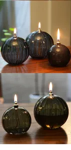 Detailansicht einer gerippten Glasöllampe mit warmer Flamme auf einem Holztisch