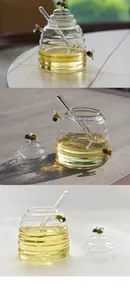 Detailed view of clear borosilicate glass honey jar with decorative bee and dipper