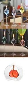 Vue détaillée d'élégantes lampes à huile en verre avec liquide coloré et flamme vacillante.
