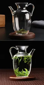 Macro di una teiera in vetro che mostra foglie di tè secche e tè in infusione.