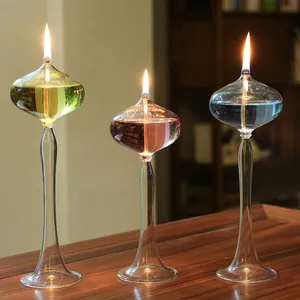 Elegant tall glass oil lamps with colorful ghee on a wooden table
