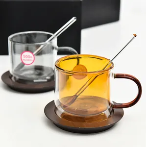 Double-walled amber and clear glass coffee cups with glass stirrers and saucers.