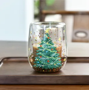 Detailansicht der doppelwandigen Weihnachtsbaum-Glastasse mit schwebendem Glitzer