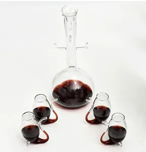 Elegante set van borosilicaatglas karaf en vier creatieve wijnglazen met rode wijn erin.