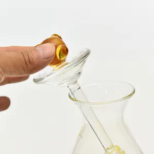 Nahaufnahme des Glasdeckelgriffs und Rührstabs eines transparenten Honigglases