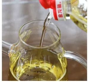 Detail close-up of a clear glass oil dispenser being filled with oil showing scale markings