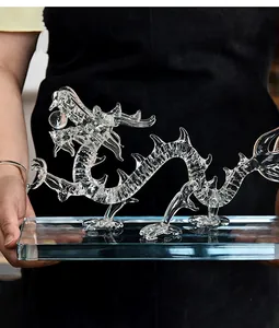 Detalle de una figura de dragón de cristal transparente sobre una base de vidrio robusta.