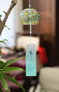 Detailed view of a colorful handmade Japanese glass wind chime with a paper tag.
