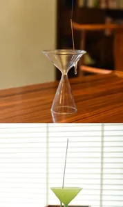 Detailed view showing clear and green glass funnel-shaped incense stick holders on table