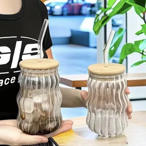 Set de elegantes tazas de café de vidrio estriado con tapas de madera y pajitas
