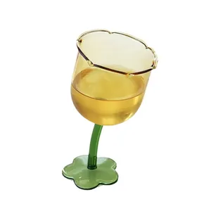 Creative flower-shaped amber glass goblet with green stem and base, tulip wine glass.