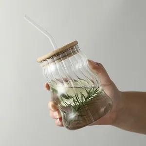 Vaso de vidrio ondulado con tapa de bambú y pajita para café y zumo.