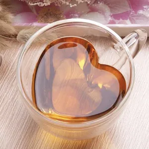 Creative heart-shaped double-walled glass coffee cup with handle on wood background
