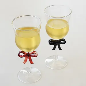 Pair of elegant champagne glasses with decorative red and black glass bows on stems