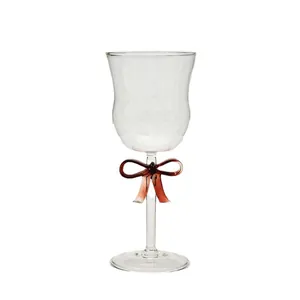 Elegant clear glass wine goblet with a creative red bow decorative element on the stem
