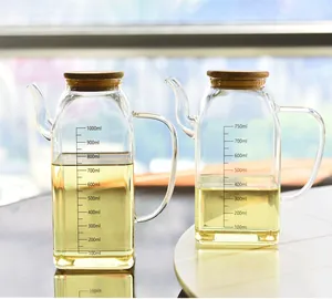 Detail showing two glass oil dispensers with measurement scales and wooden lids