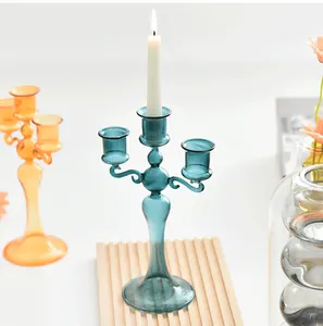 Close-up of a blue French glass three-arm candelabra with a lit white candle