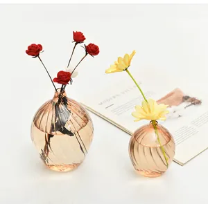 Detail of champagne ribbed glass vases with minimalist spiral texture and flowers