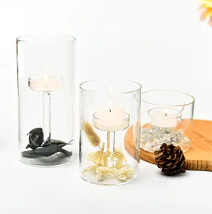 Juego de tres portavelas cilíndricos de cristal con flores secas decorativas