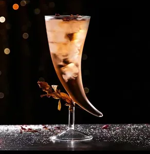 Détail d'un élégant verre à cocktail unique en forme de corne avec glaçons et boisson