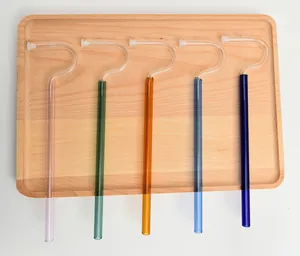 Five colorful anti-lip wrinkle glass straws with unique flute design on a wooden tray.