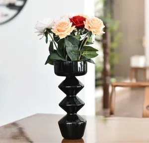 Dettaglio di un moderno vaso geometrico in vetro nero con rose artificiali fini